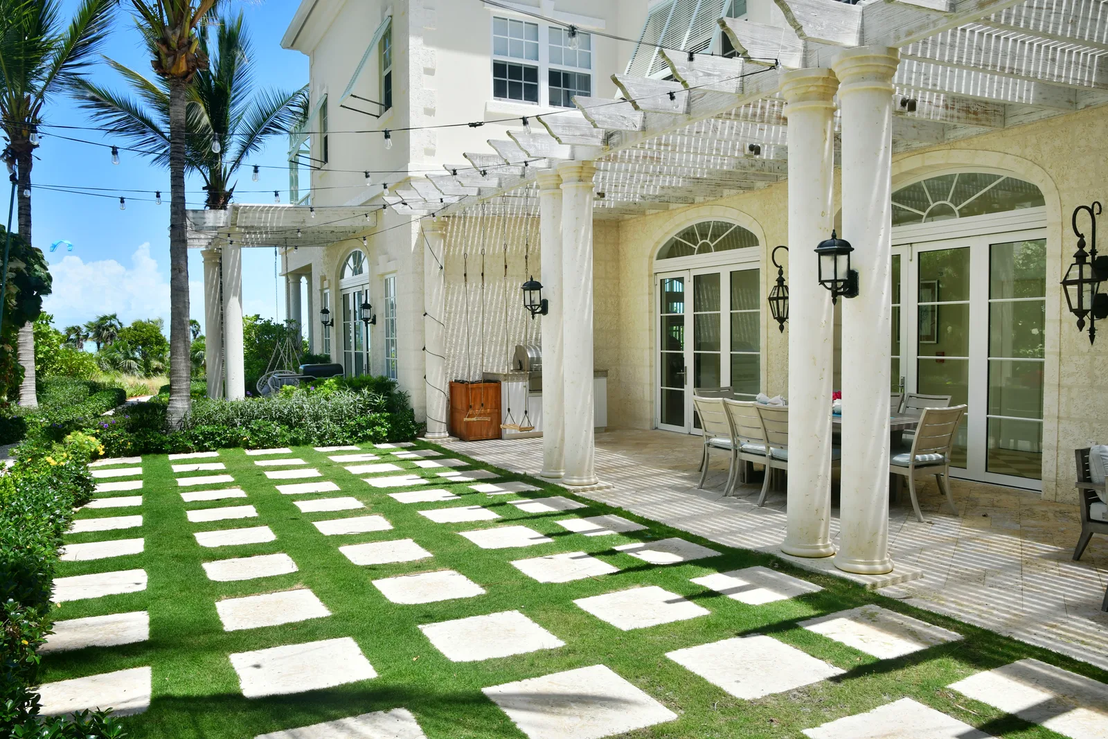 The courtyard lawn and its stone grid, columns and pergola