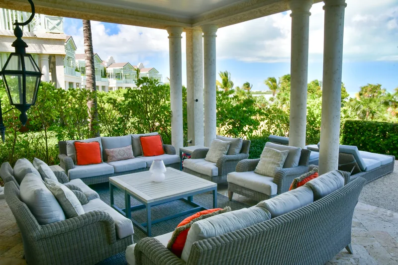 The covered terrace and its wicker lounge, the garden beyond