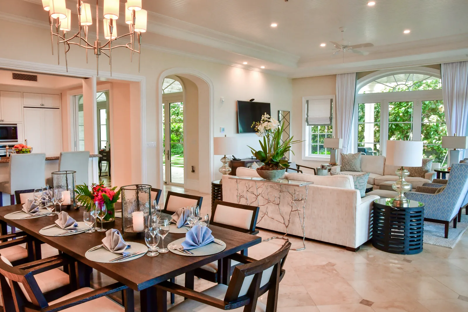 The dining table set for dinner, the living room beyond