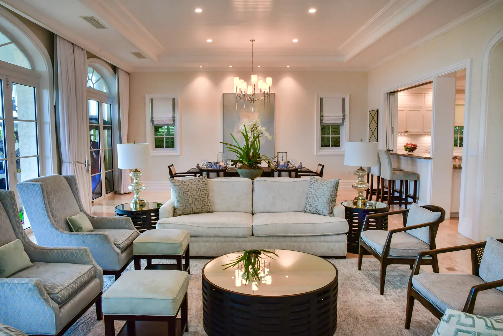 The great room: sofas, armchairs and the dining table under high ceilings